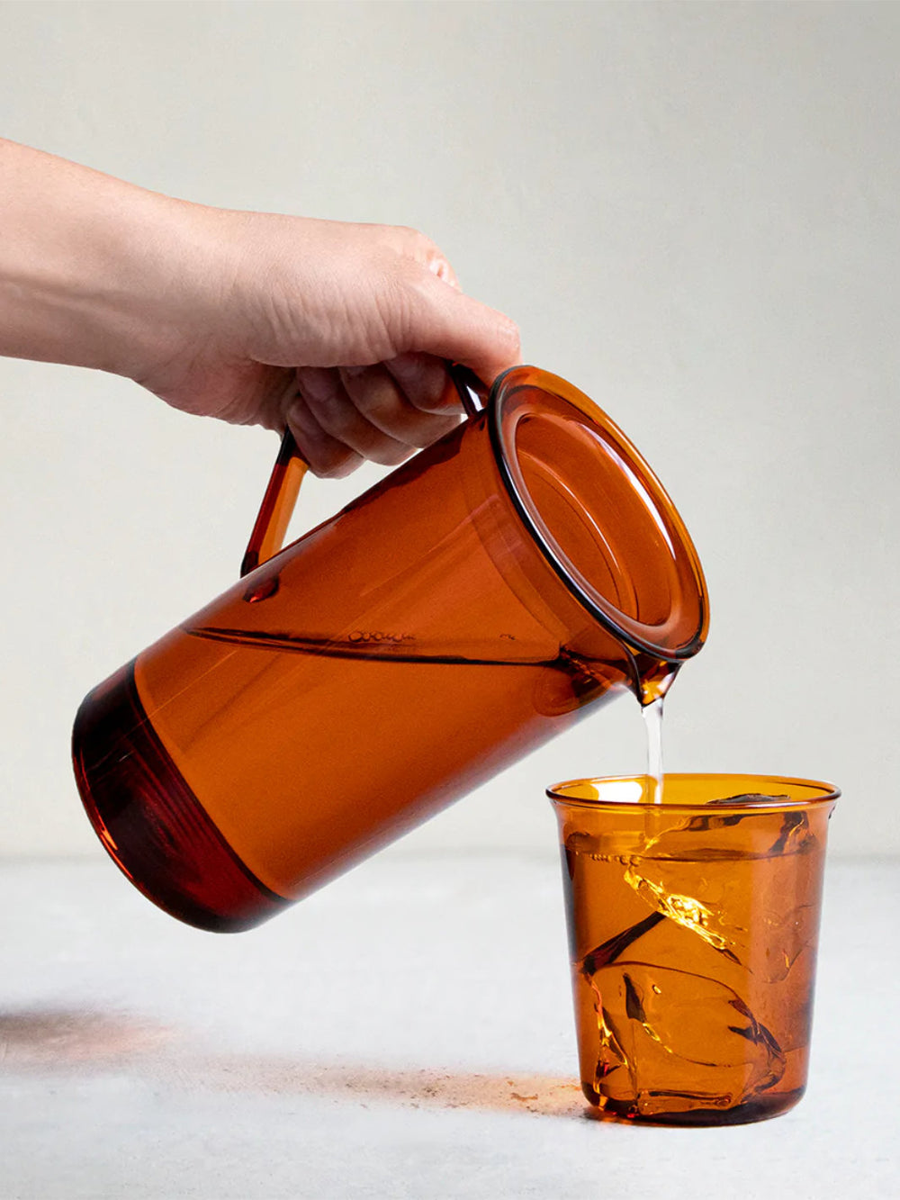 https://cdn.shopify.com/s/files/1/2404/0687/products/kinto_21463_cast-amber-jug-750ml_pouring-water_alt.jpg?v=1669833561&width=1000