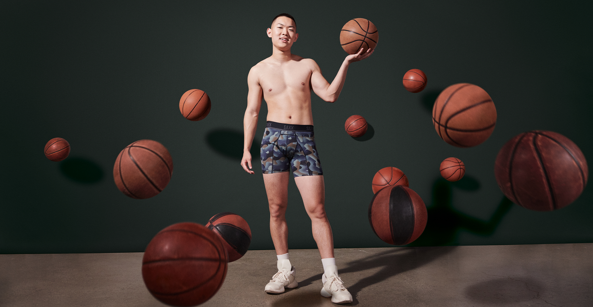 Man in sport boxer briefs surrounded by basketballs