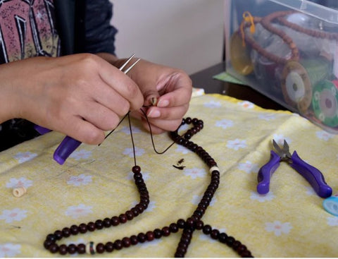 Woman repairing mala beads