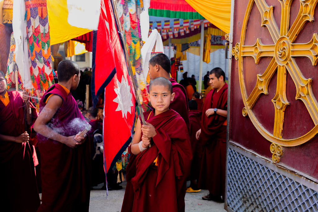 Novice monk holding Nepalese flag