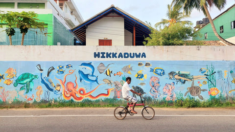 Man Bicycling Past HIKKADUWA Sign Outside Hikka-Tranz By Cinnamon Beach Resort | Cinnamon Hotels | Hikkaduwa | Sri Lanka | Australian Cricket Tours