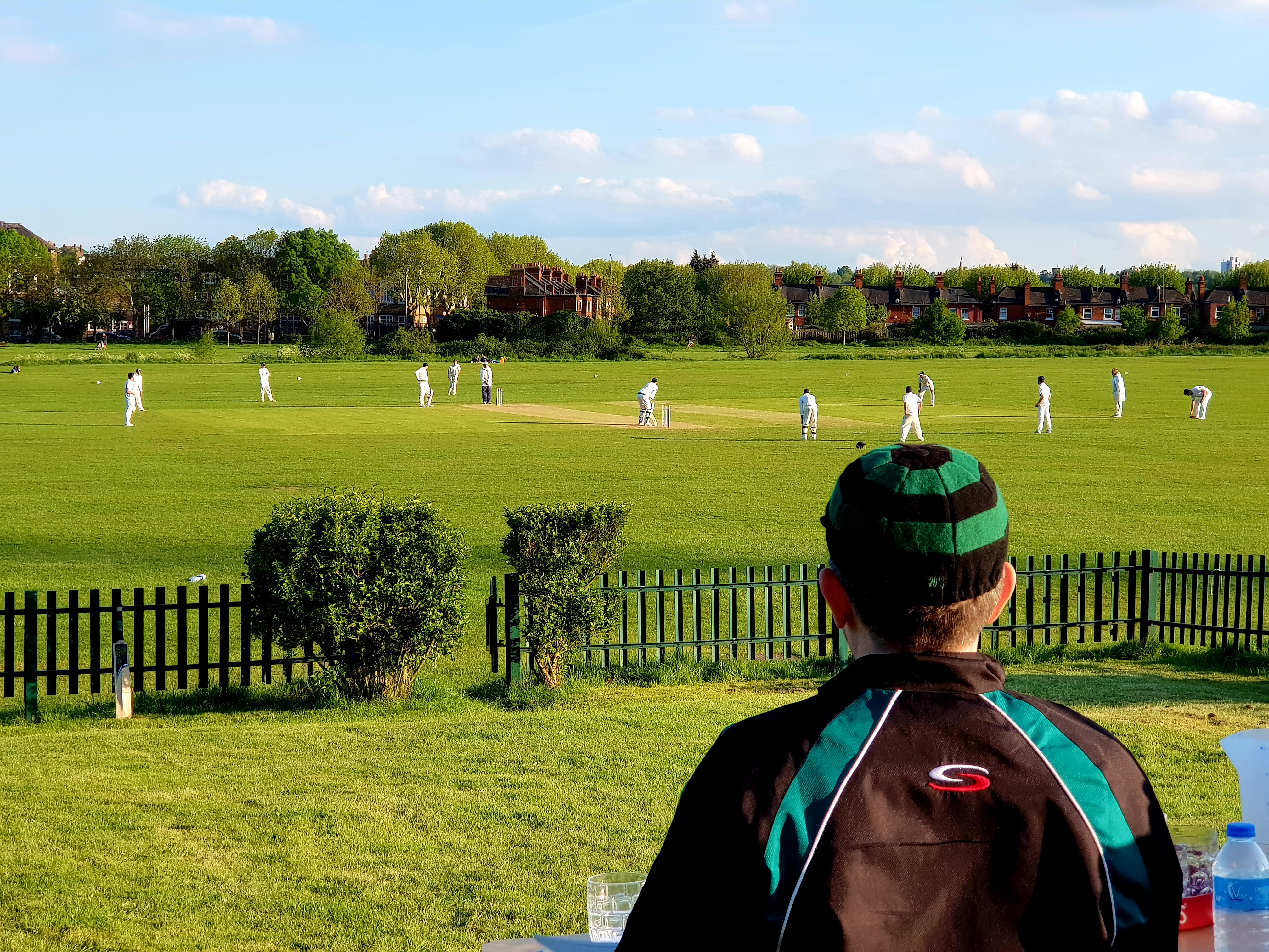 Australian Cricket Tours - A Players Sits On The Hill Looking Down Over A Match At Alexandra Park Cricket Club, London