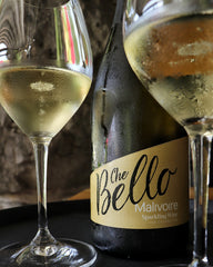 Image shows bottle of Che Bello Sparkling Wine with two glasses of sparkling wine in front.