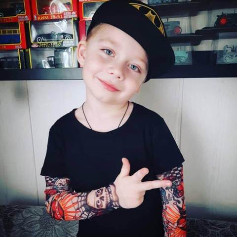 Child wearing a t-shirt with tattoos on the sleeves