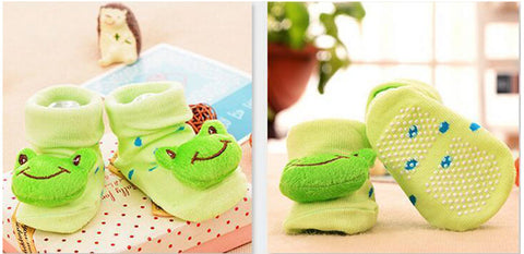 pair of socks with a green fabric frog sewn on top