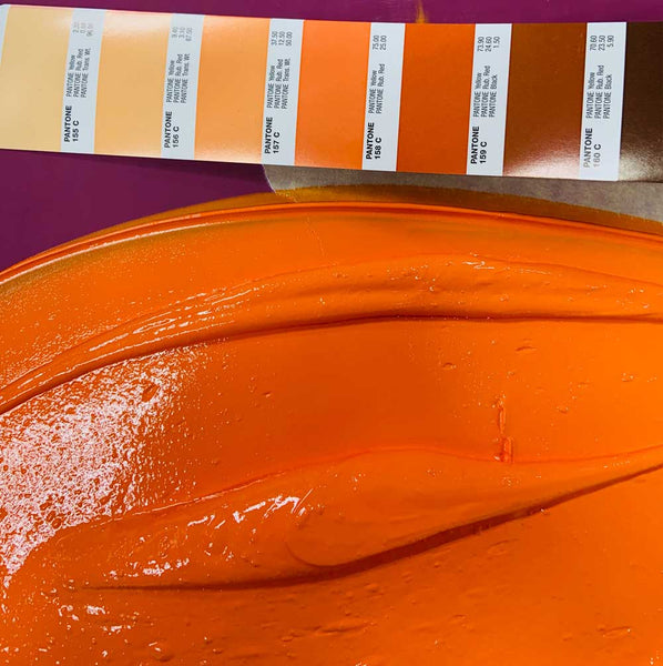 Different swatch of orange and yellow pantone colors shown with a mix of orange screen printing ink to compare consistency in ink colors