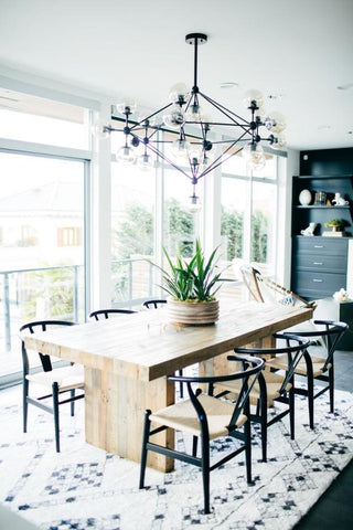 gemetric black frame farmhouse chandelier over dining room with black herringbone chair