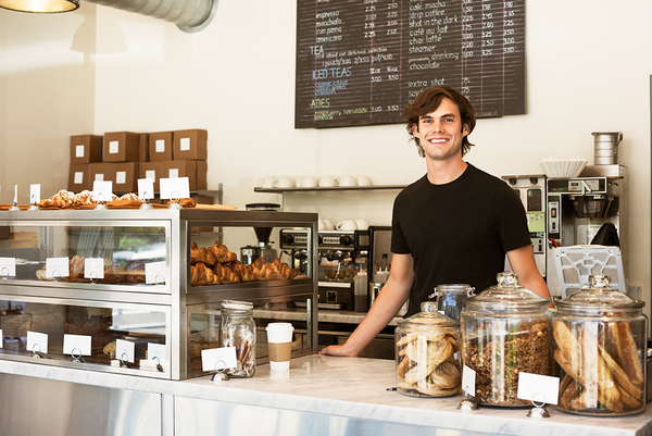 man standing in front of coffee shop menu