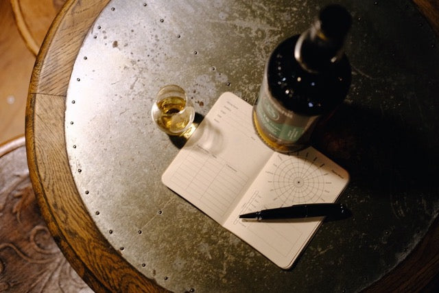 Open Whisky tasting notes with whisky bottle and pen