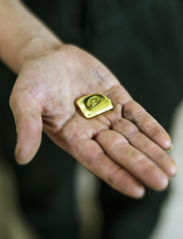 Fairmined Gold bar in the palm of a miner's hand