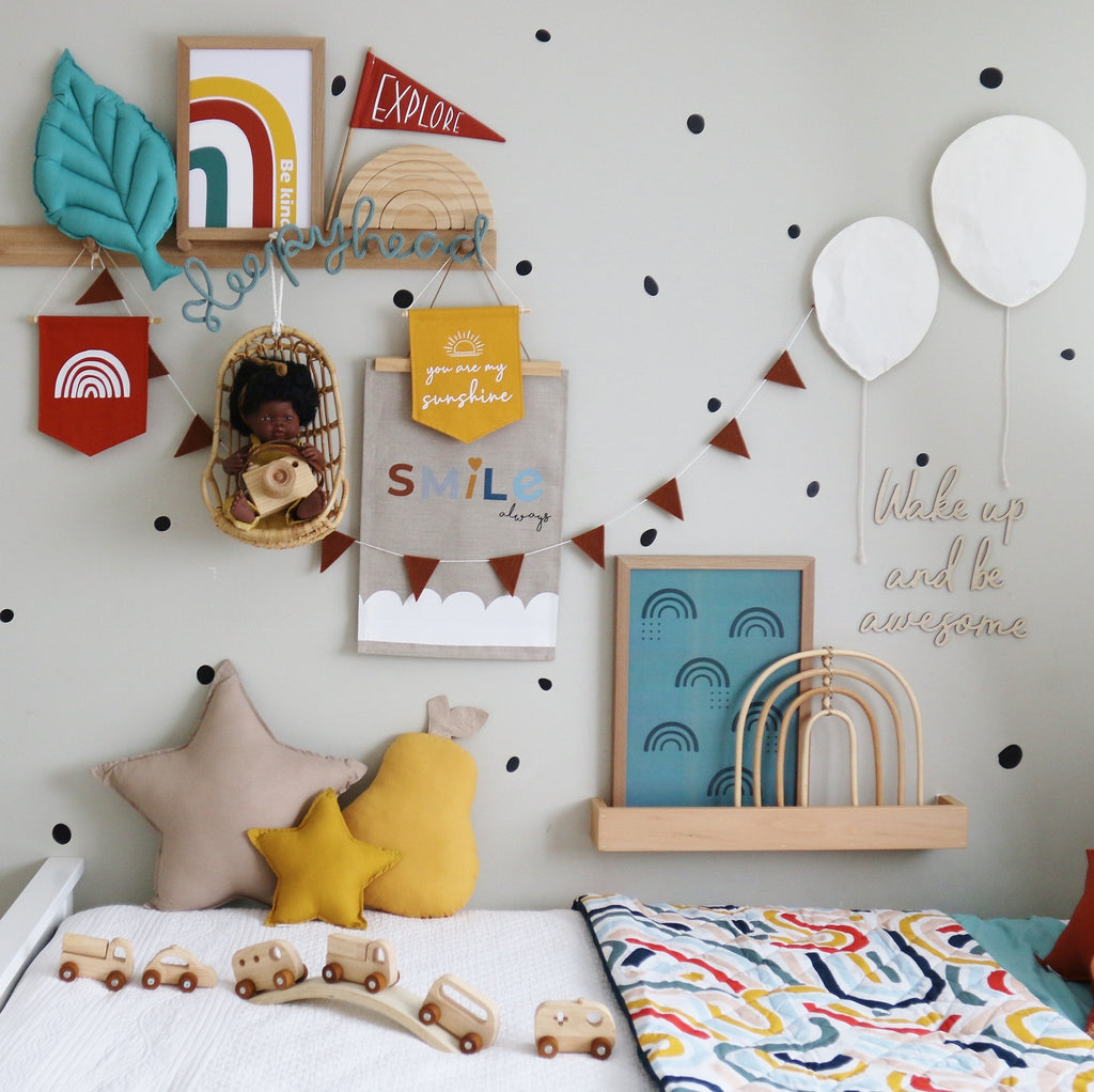 Kids room styled by Squiggly Monkeys with red rainbow pennant and mint soft leaf on wooden shelf