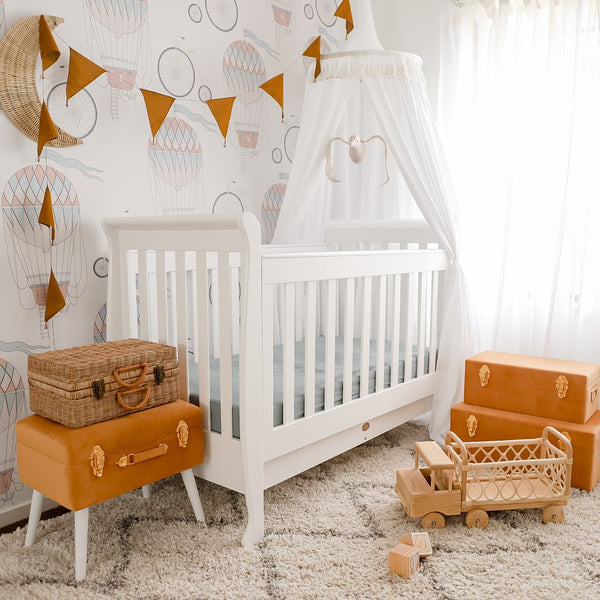 white round canopy draped over white cot in gender neutral baby nursery 