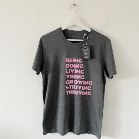 Grey Graphic Print Tee with the words Being, Doing, Living, Vibing, Growing, Thriving, Sriving in pink print