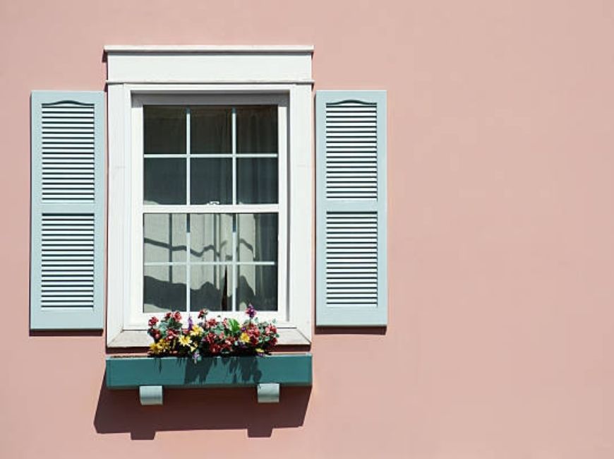 pink house with light blue house and flower box