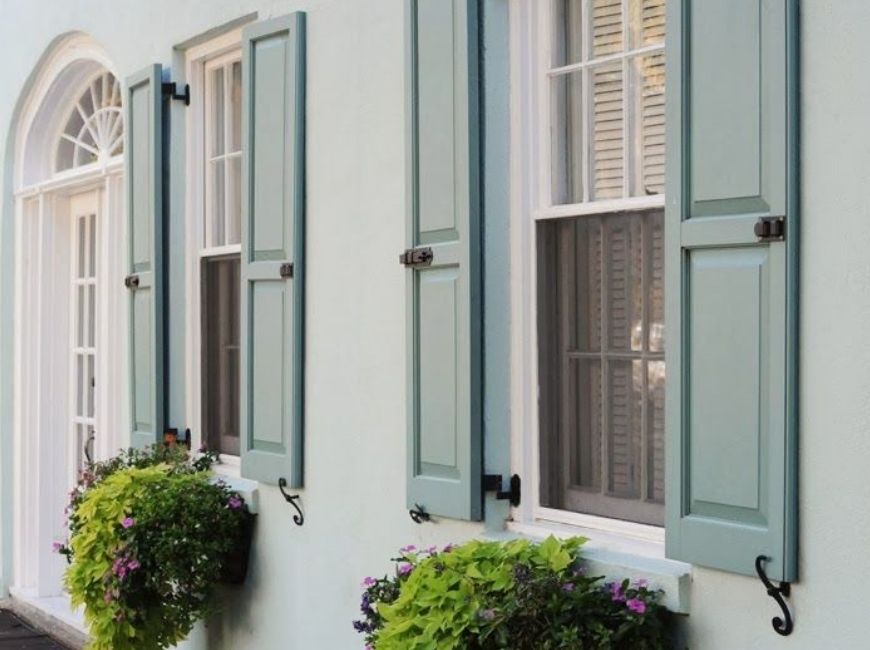 white house with blue/green shutters and window boxes