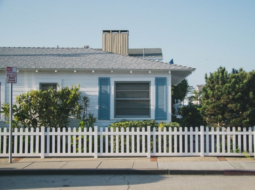 house with white fence and blue shutters