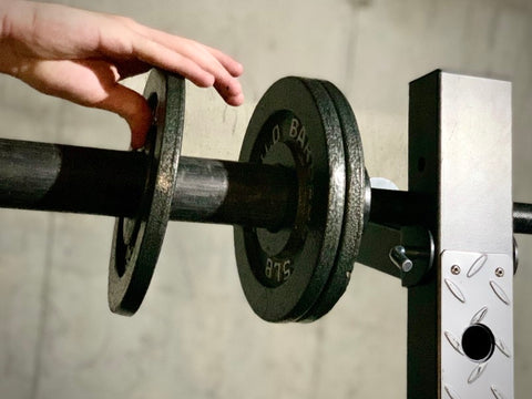 Close up of hands adding plates to lifting bar
