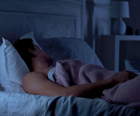 Man sleeps soundly at night in his bed under covers