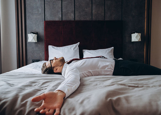 exhausted businessman resting on bed