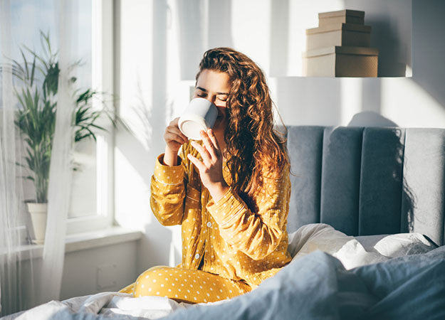 woman drinks coffee in bed