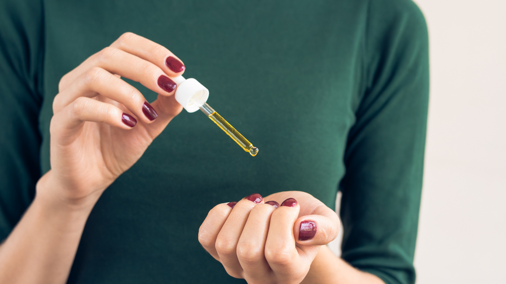 Women applying Plantonix Neem Bliss on her skin through a dropper.