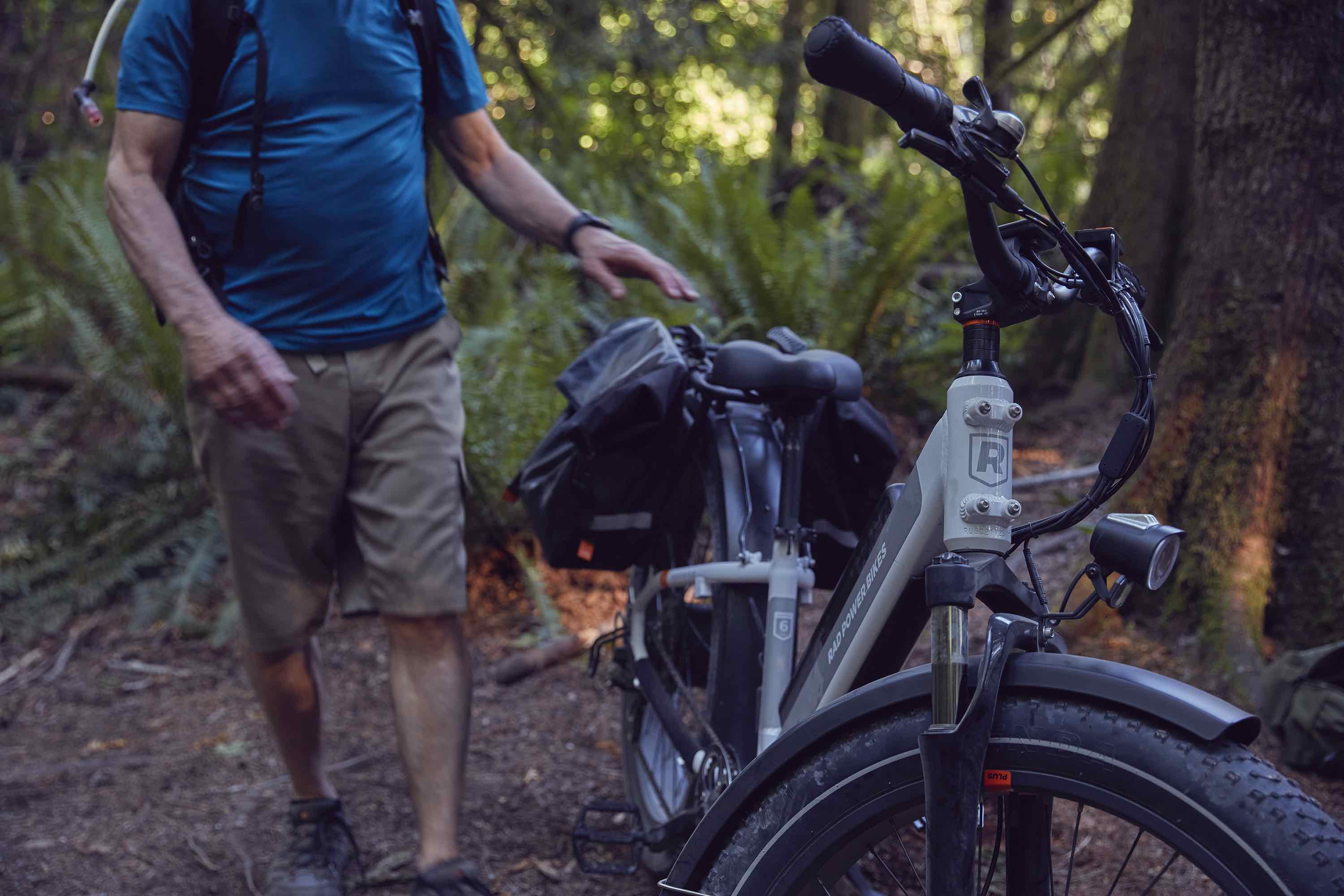 A man walks his RadRover 6 Plus through the woods.