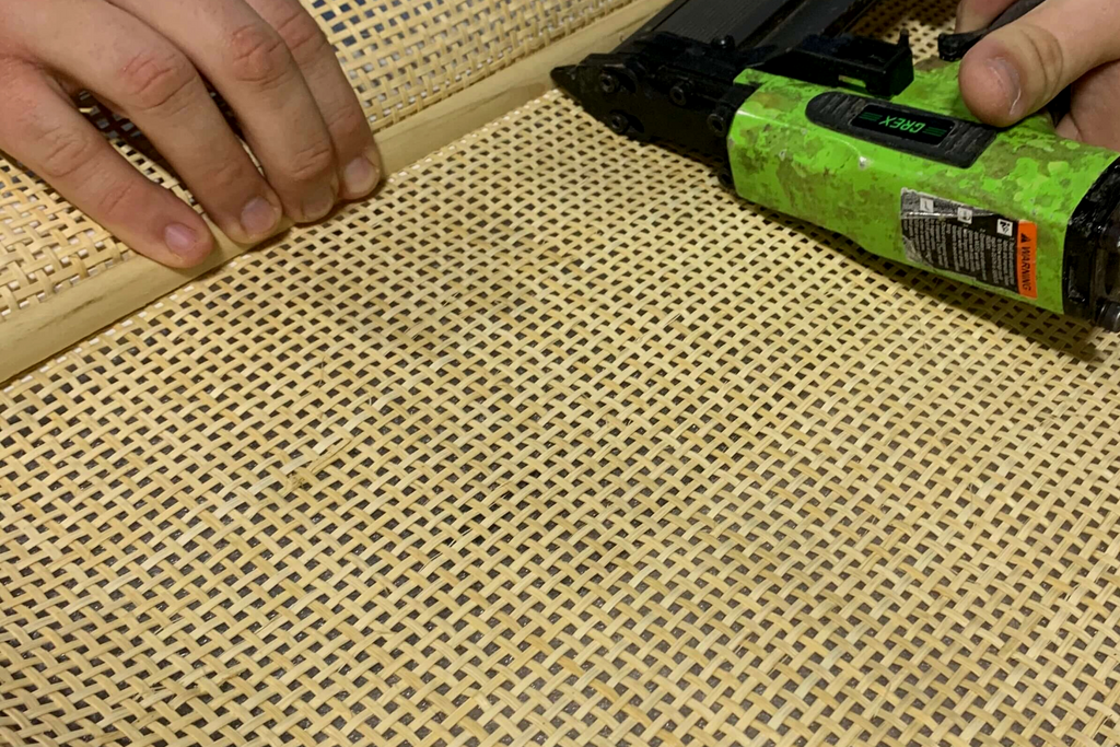 Securing the cane with nails in the poplar wood moulding