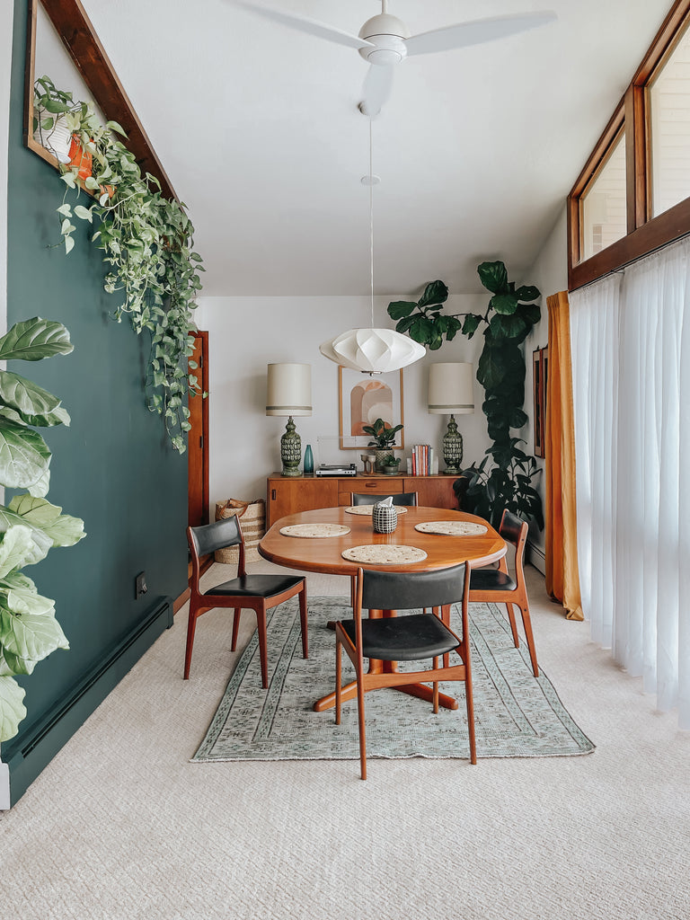 Eco-chic dining table with wall plants and green painted interior