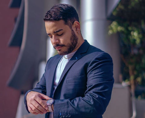 bearded man in a suit checking watch