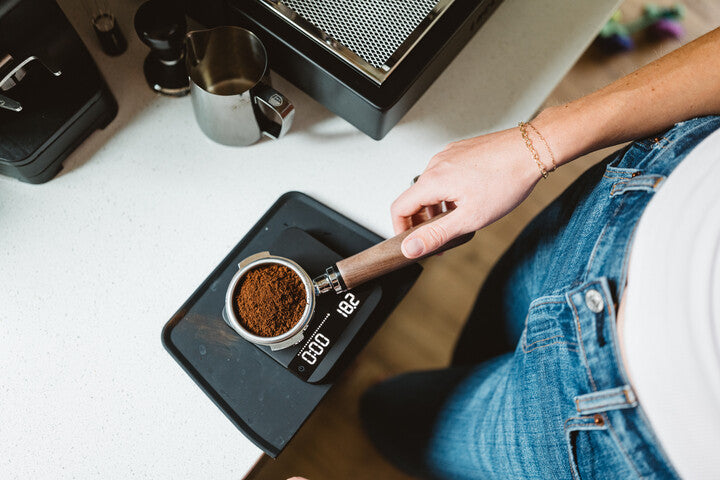 measuring coffee grounds on a scale top view lifestyle by clive coffee