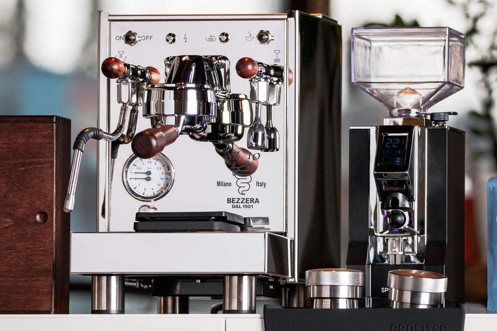 Bezzera BZ10 espresso machine with wood accents next to the Eureka Specialita espresso grinder in black.