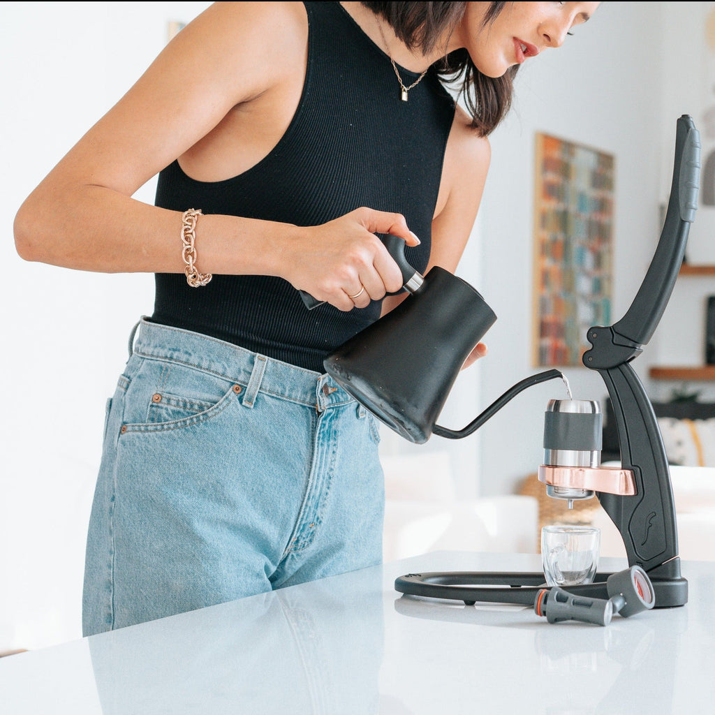 Woman pouring water into the brew chamber of a Flair espresso maker lifestyle photo by Flair Espresso