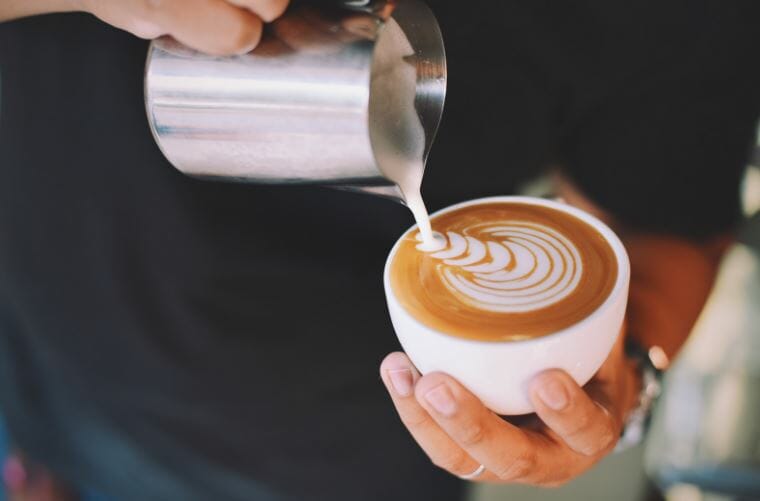 barista pouring latte art lifestyle by clive coffee
