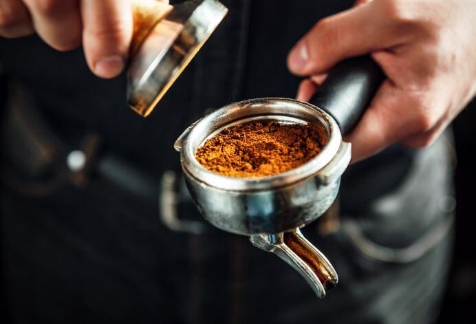 barista tamping a puck of coffee lifestyle by clive coffee