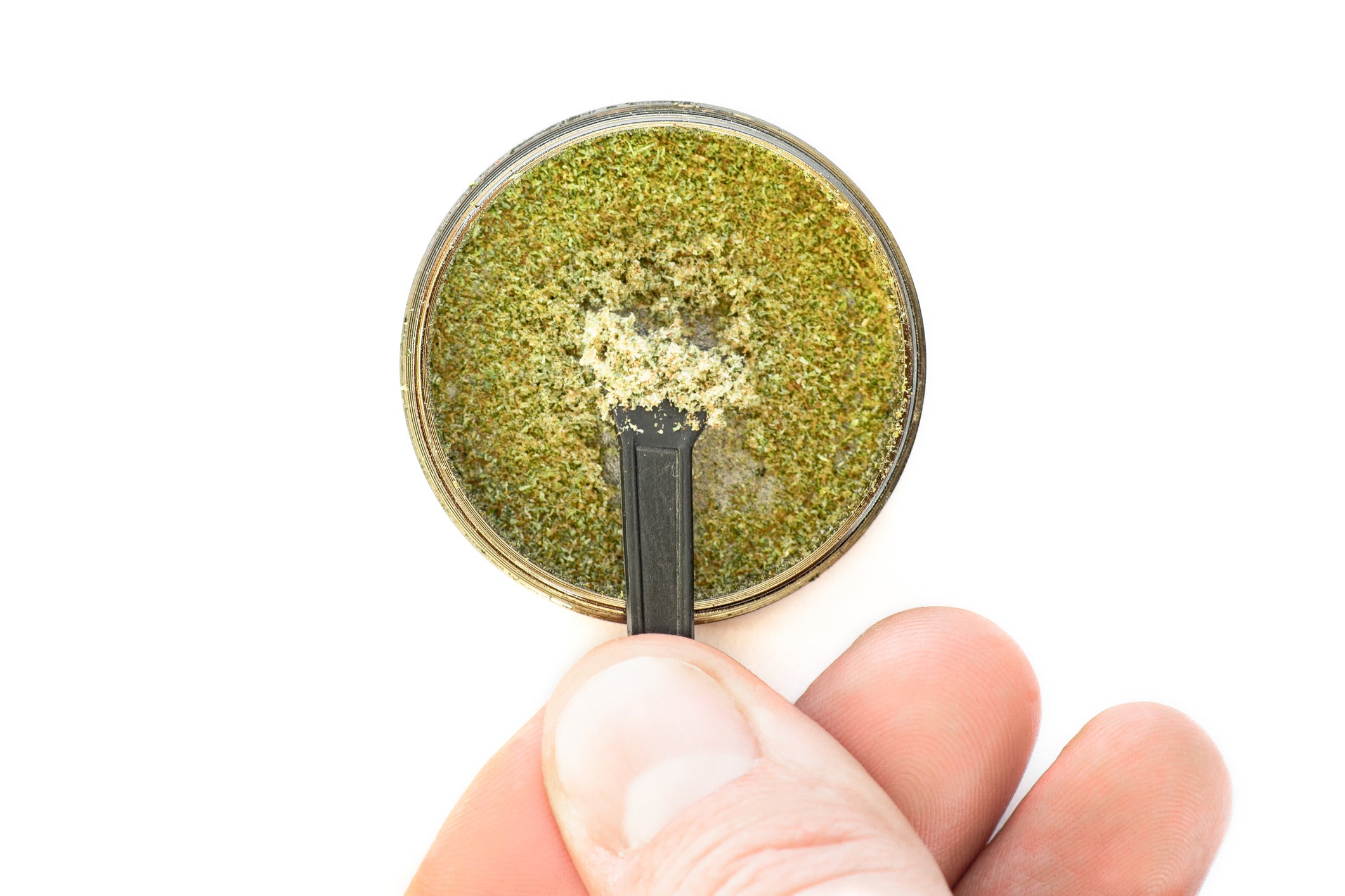 The rich trichomes of kief, a cannabis concentrate, are being stirred and scooped out of a bowl.