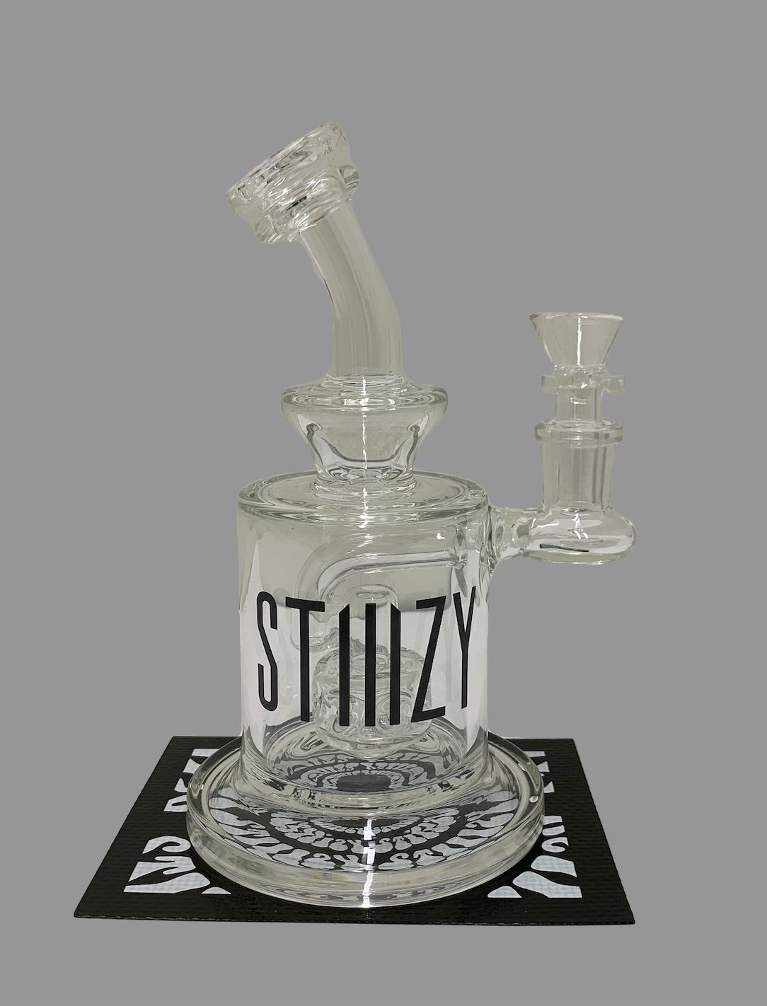 A large glass dab rig with STIIIZY written in black letters is ready for dabbing cannabis concentrates.