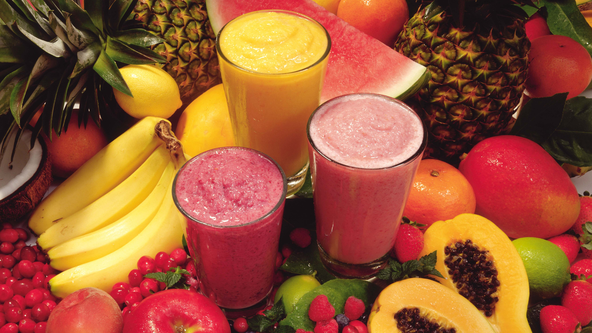 tropical fruit smoothies surrounded by fresh fruit