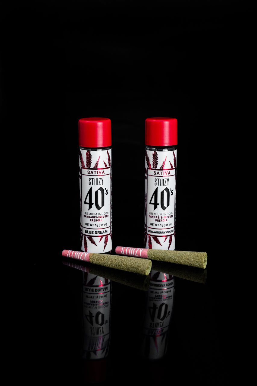 Two infused cannabis pre-rolls with a sativa strain lie in front of their red-capped jars.