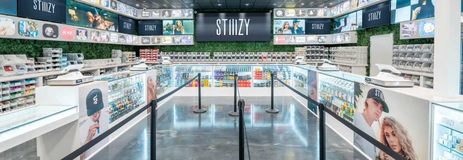 A spacious weed dispensary with black STIIIZY signs offers a variety of cannabis products in its glass counters.