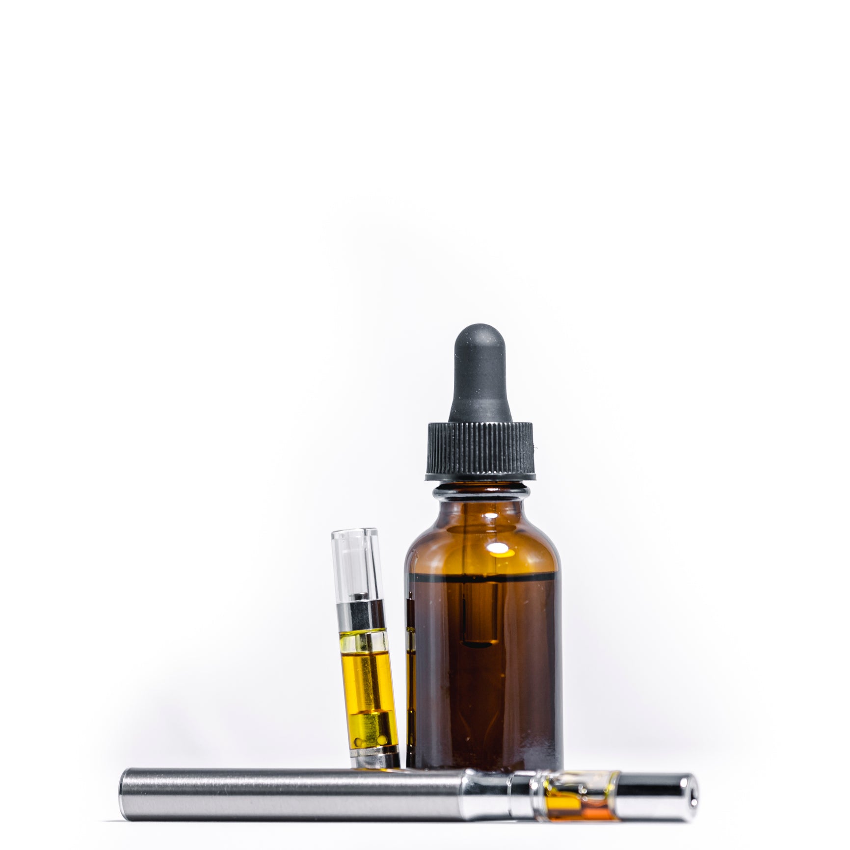 A weed vape pen and cartridge with THC oil lie next to a vial with cannabis distillate.