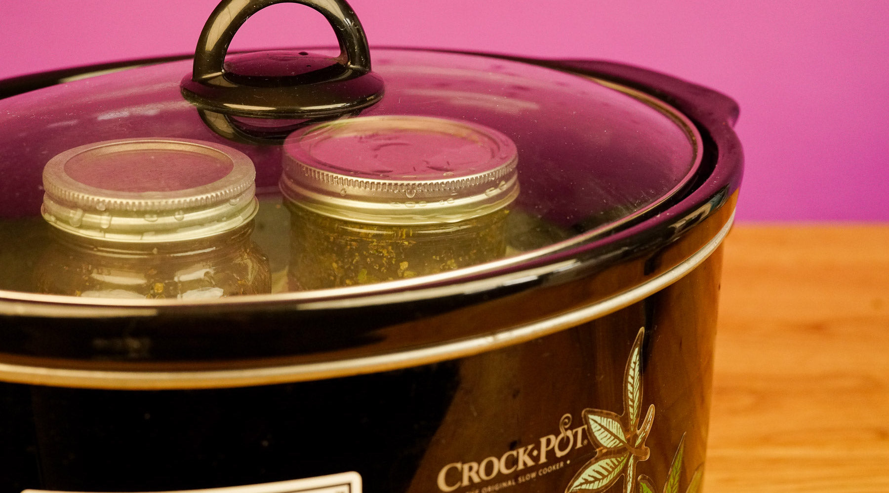 two mason jars in a crock pot filled with decarbed weed and butter to make cannabutter in a crock pot