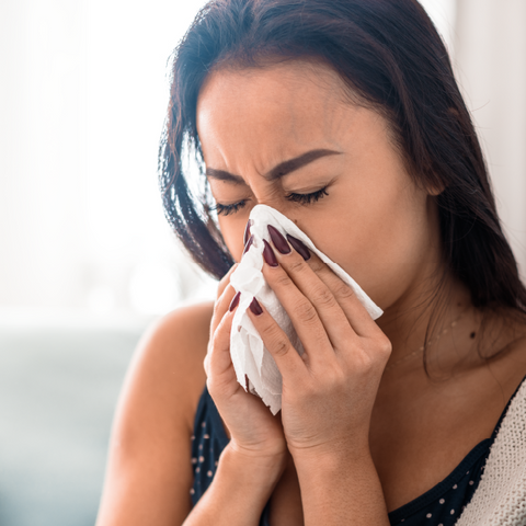 A woman blowing her nose