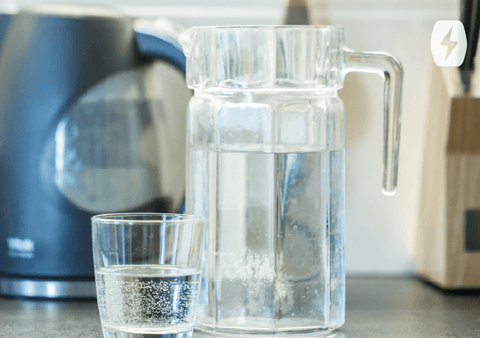 Glass of water next to a pitcher