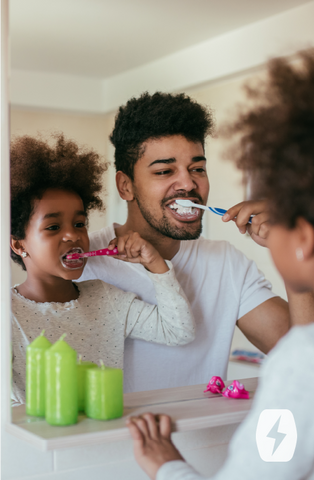 A father and daughter brush their teeth