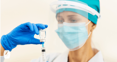 A nurse holds a vaccine in a shot