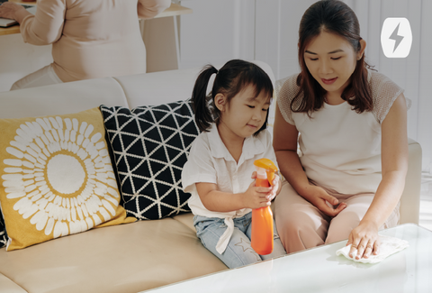 A mom and daughter spray a surface