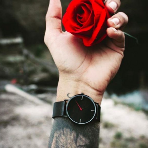 Man holding rose with black watch on