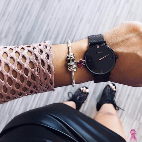 Woman Wearing Black Minimalist Watch with Pink Minute hand and pink crystal 