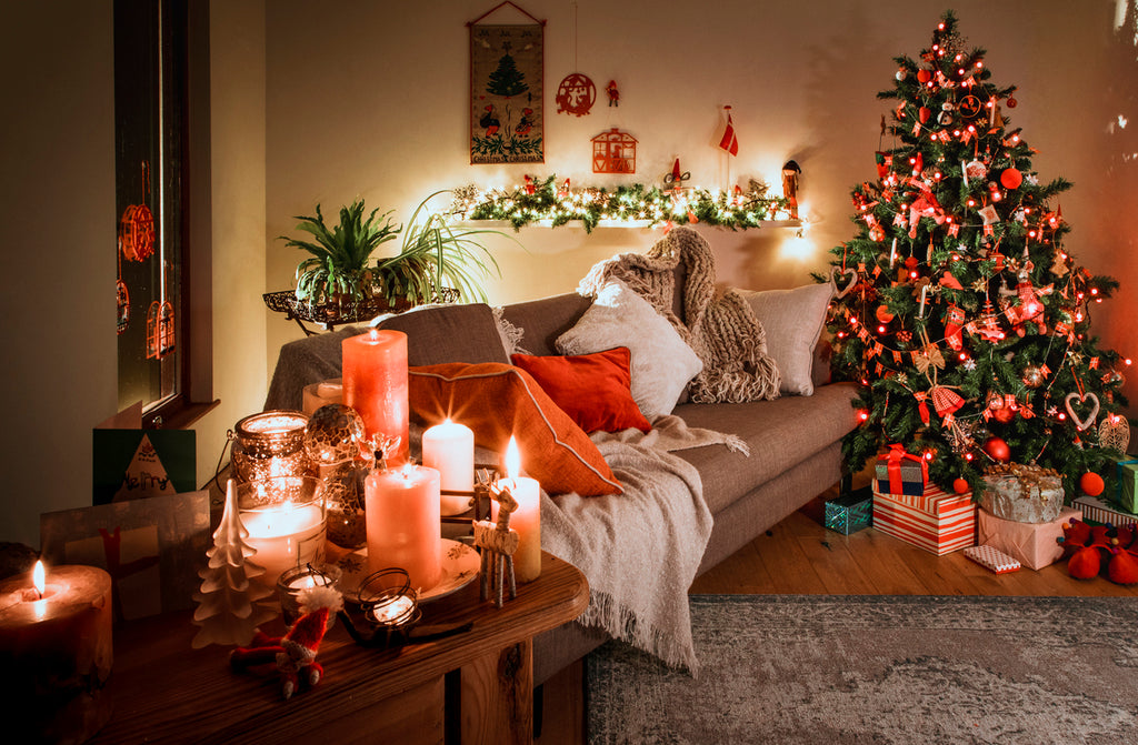 Christmas Scene with traditional homemade Danish Christmas Decorations. Warmth of the candles and fairy lights. Christmas tree with gifts underneath
