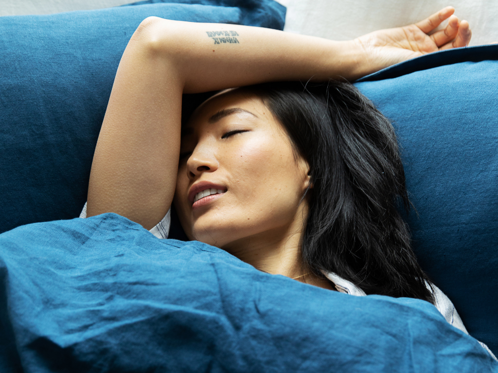 Woman resting in blue organic linen duvet covers from The Modern Dane